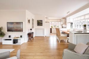 a living room with a kitchen and a dining room at Hüs Freesenborg in Oldsum +21 photos