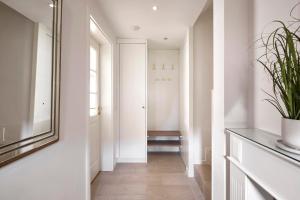 a hallway with white walls and a mirror at Hüs Freesenborg in Oldsum