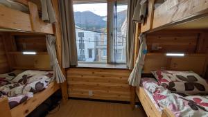two bunk beds in a room with a window at Hakodate Stay Walk to Onsen and History in Hakodate