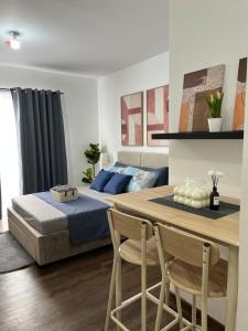 a bedroom with a bed and a table and chairs at JeMeCa Suites in Kauswagan