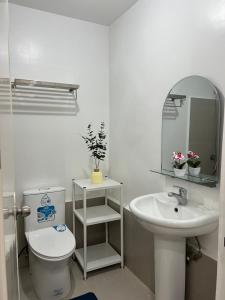 a bathroom with a sink and a toilet and a mirror at JeMeCa Suites in Kauswagan