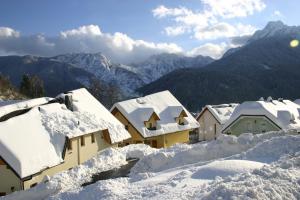 un groupe de maisons recouvertes de neige dans l'établissement Apartments Karmen, à Rateče