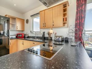 een keuken met houten kasten en een aanrechtblad bij Beachview in Llanelli