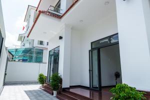 a white building with glass doors and plants at HomyPlus Apartment in Ho Chi Minh City