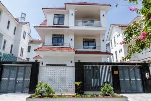 a white building with black gates in front of it at HomyPlus Apartment in Ho Chi Minh City
