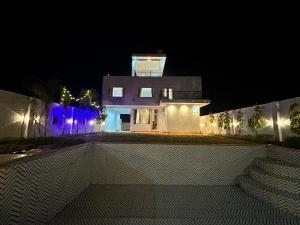 une maison avec une tour éclairée la nuit dans l'établissement Mangal Uday Villa, à Jaipur