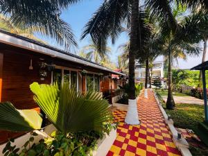 a resort with palm trees and a checkered floor at Maitree Beach Resort in Arambol