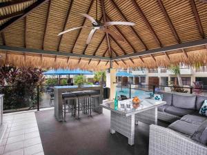 an outdoor patio with a couch and a table at Mantra Heritage in Port Douglas