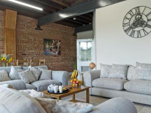 een woonkamer met banken en een klok aan de muur bij Church View - Ukc2302 in Wainfleet All Saints