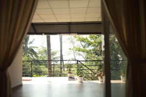 an open window with a view of a balcony at Kghomestay in Pallipuram