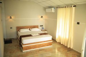 a bedroom with a bed and a window at Kghomestay in Pallipuram