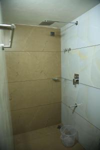 a bathroom with a shower with a glass door at Kghomestay in Pallipuram