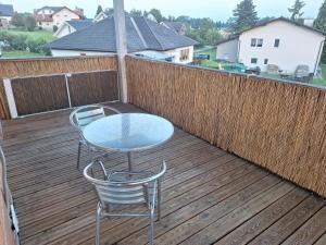 a table and two chairs on a wooden deck at Familienwohnung Emprechting in Emprechting