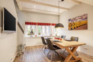 a dining room with a wooden table and chairs at FöhrEuch 2 in Borgsum