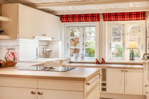 a kitchen with white cabinets and a red curtain at FöhrEuch 2 in Borgsum