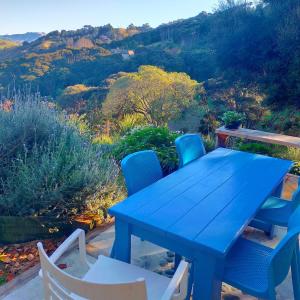 a blue table and chairs with a view of the mountains at Delightful Dolphin 'Lodge' in Akaroa