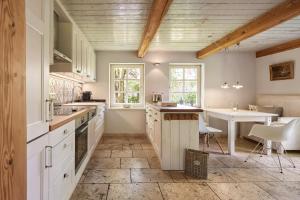 een keuken met witte kasten en een tafel. bij Haus Augenblick in Utersum