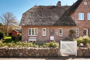 an old brick house with a thatched roof at Landhaus Meta in Wrixum