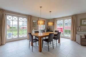 a kitchen and dining room with a table and chairs at Landhaus Meta in Wrixum