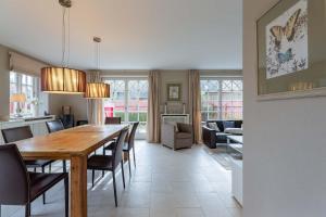 a dining room and living room with a table and chairs at Landhaus Meta in Wrixum +21 photos