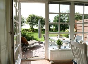 una porta aperta su un patio con tavolo e sedie di Hausteil Tornerose a Witsum