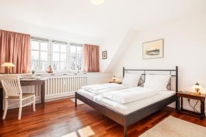 una camera da letto con un letto, una scrivania e una sedia di Hausteil Tornerose a Witsum