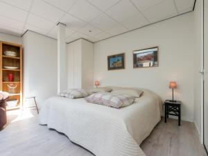 een witte slaapkamer met een groot bed met 2 kussens bij Alluring Apartment in Bergen with Terrace, Garden and BBQ in Bergen +32 foto's