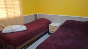 Cette chambre dispose de 2 lits et d'une table de nuit avec un lit sidx sidx sidx. dans l'établissement Departamento Villa Libertad, à Leandro N. Alem