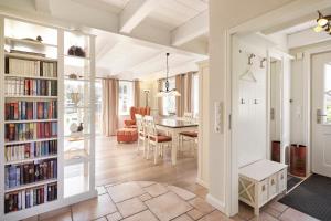 een eetkamer en woonkamer met boekenplanken bij Reethüs Marta - rechts in Utersum