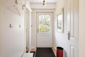 een hal met een witte deur en een raam bij Reethüs Marta - rechts in Utersum