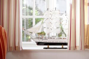 een modelschip op een vensterbank bij Reethüs Marta - rechts in Utersum +11 foto's