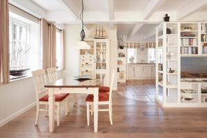 een eetkamer met een tafel en stoelen bij Reethüs Marta - rechts in Utersum