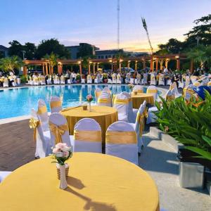 a group of tables and chairs in front of a pool at Đất Quảng Villa in An Tân