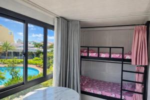 a bedroom with bunk beds and a view of the pool at Đất Quảng Villa in An Tân