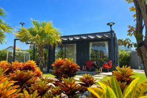 a small black house with red chairs and palm trees at Đất Quảng Villa in An Tân +55 photos
