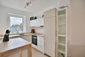 a kitchen with white cabinets and an open refrigerator at City Marina, CM20a in Cuxhaven