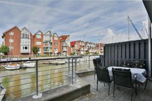 a balcony with a table and chairs next to a river at City Marina, CM20a in Cuxhaven