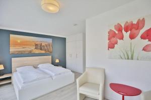 a bedroom with a white bed and a red chair at City Marina, CM20a in Cuxhaven +15 photos