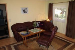 a living room with a leather couch and a table at Am Hang - ABC163 - nur Feriengäste! in Pinnow