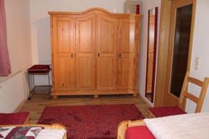 a bedroom with a wooden cabinet and a red rug at Am Hang - ABC163 - nur Feriengäste! in Pinnow