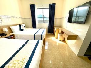a hotel room with two beds and a flat screen tv at Khách Sạn Ba Đoàn 1 in Con Dao