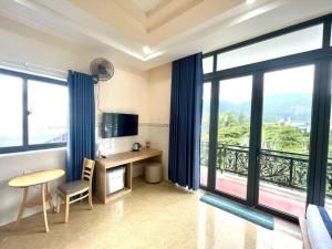 a hotel room with a desk and large windows at Khách Sạn Ba Đoàn 1 in Con Dao