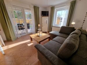 a living room with a couch and a table at Ferienhaus Sommerwiese - ABC327 in Klein Warin
