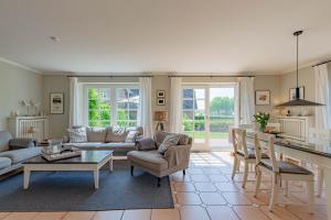 a living room with a couch and a table at Reetdachhaus Hedehusum in Hedehusum +29 photos
