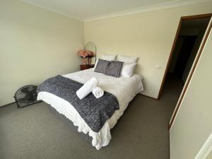 a bedroom with a large bed with two pillows at The little beach house in Tuross Heads
