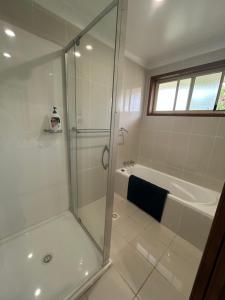 a bathroom with a shower and a bath tub at The little beach house in Tuross Heads