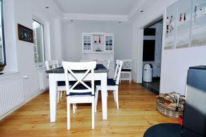 a white dining room with a table and chairs at Fischers Fritz - Brückstr 32 in Heiligenhafen