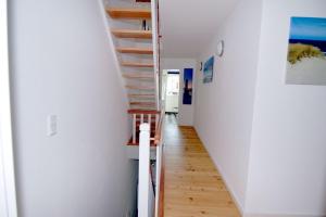 a staircase in a house with white walls and wooden floors at Fischers Fritz - Brückstr 32 in Heiligenhafen