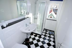a white bathroom with a sink and a toilet at Fischers Fritz - Brückstr 32 in Heiligenhafen +10 photos