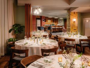 een eetkamer met tafels en stoelen met witte tafels bij The Hoxton Vienna in Wenen